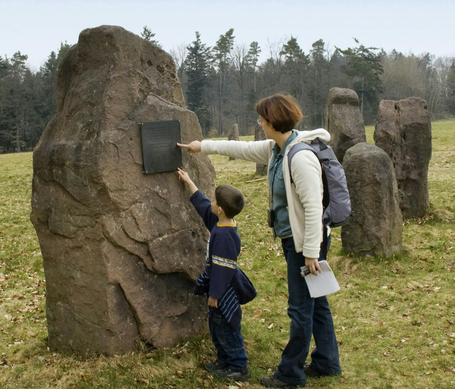 Mutter mit Kind beim Erkunden eines Steines
